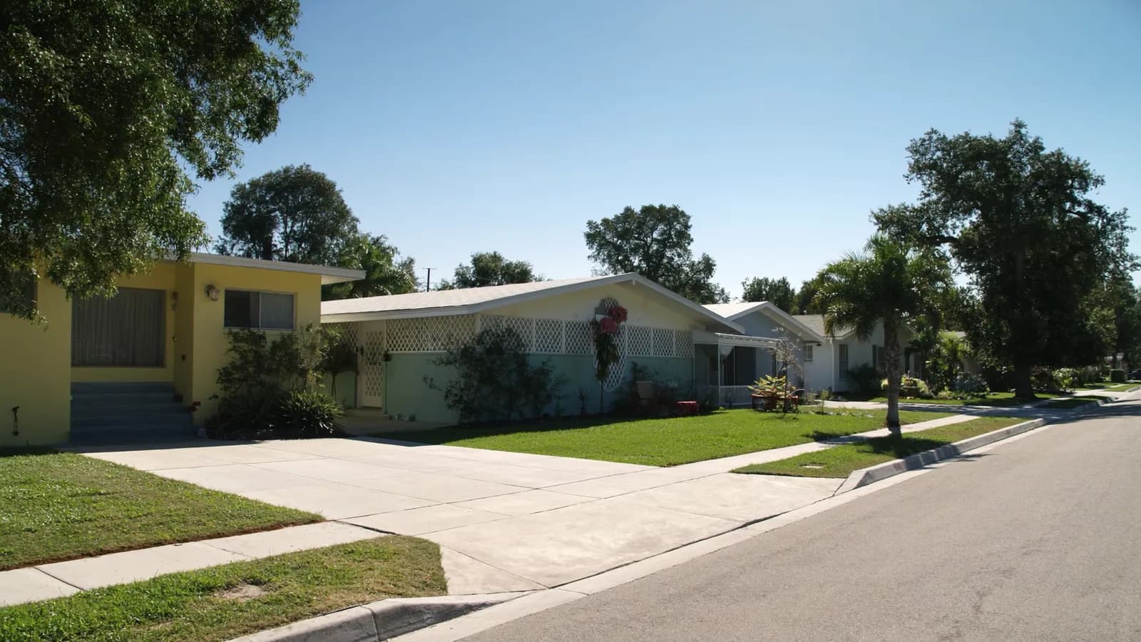 A sunlit street of single-storey South Florida homes