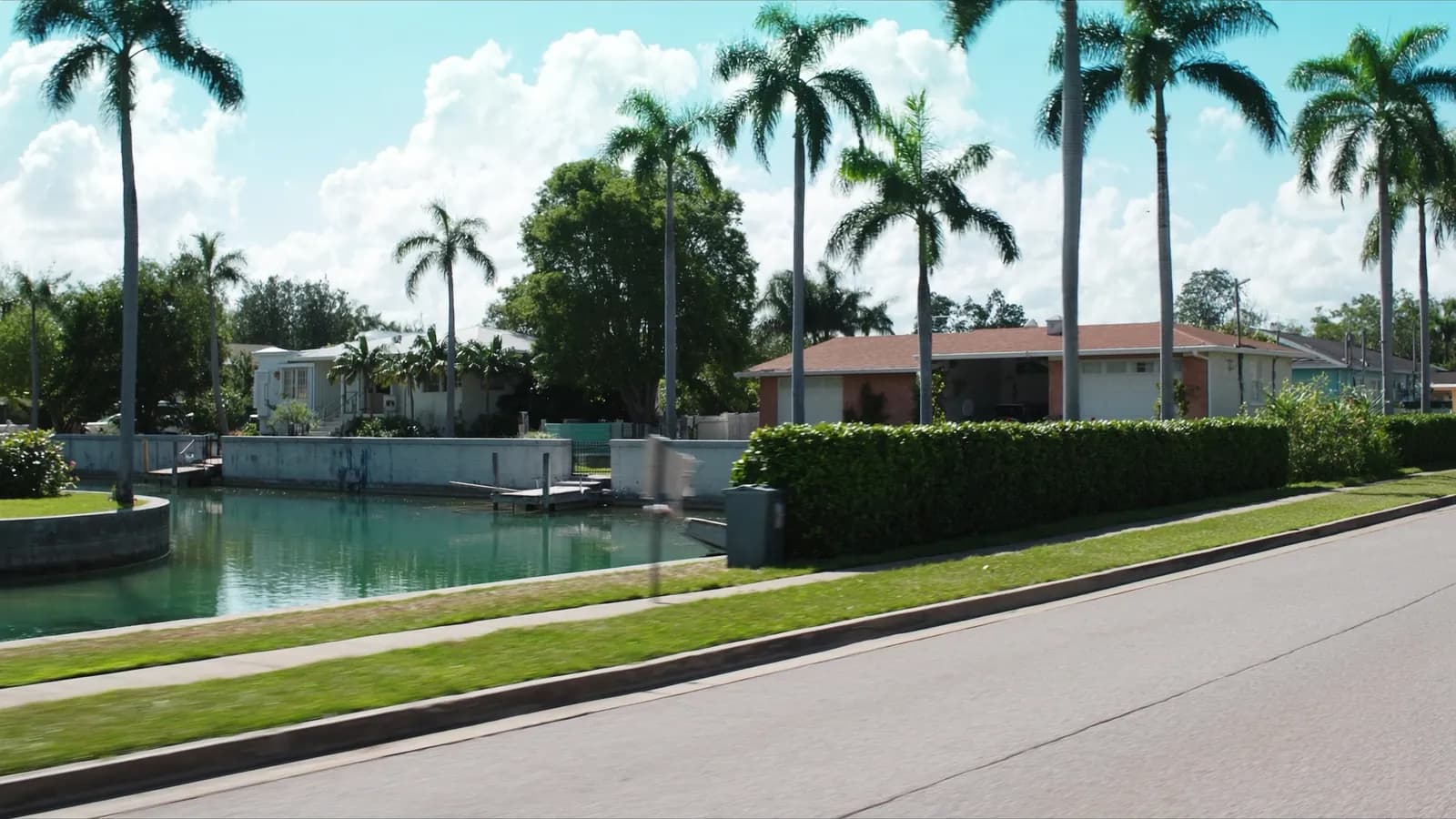 Canal-front street of mid-century single-storey homes in North Miami, Florida